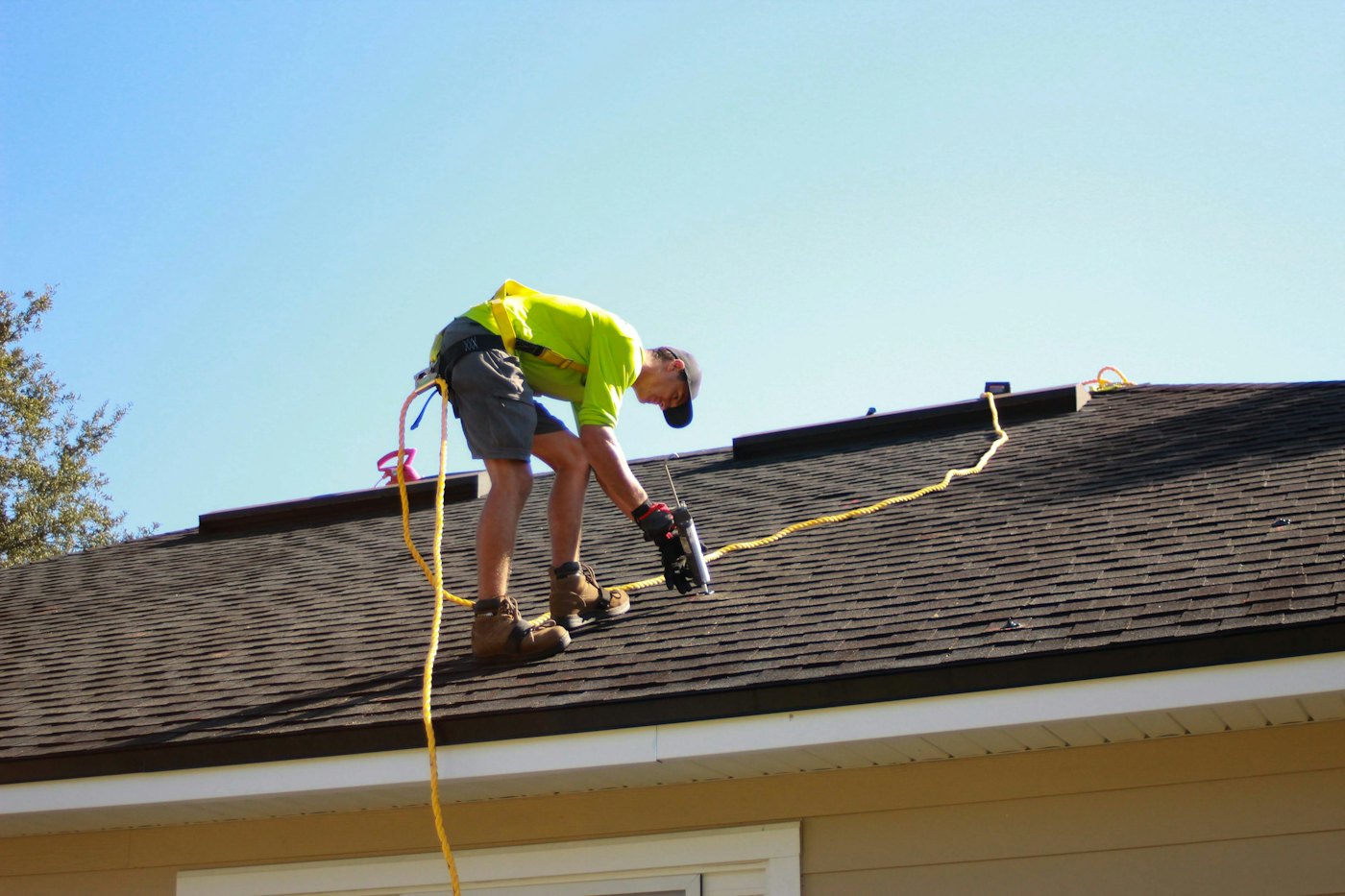 Roofer repairing a roof with a drill