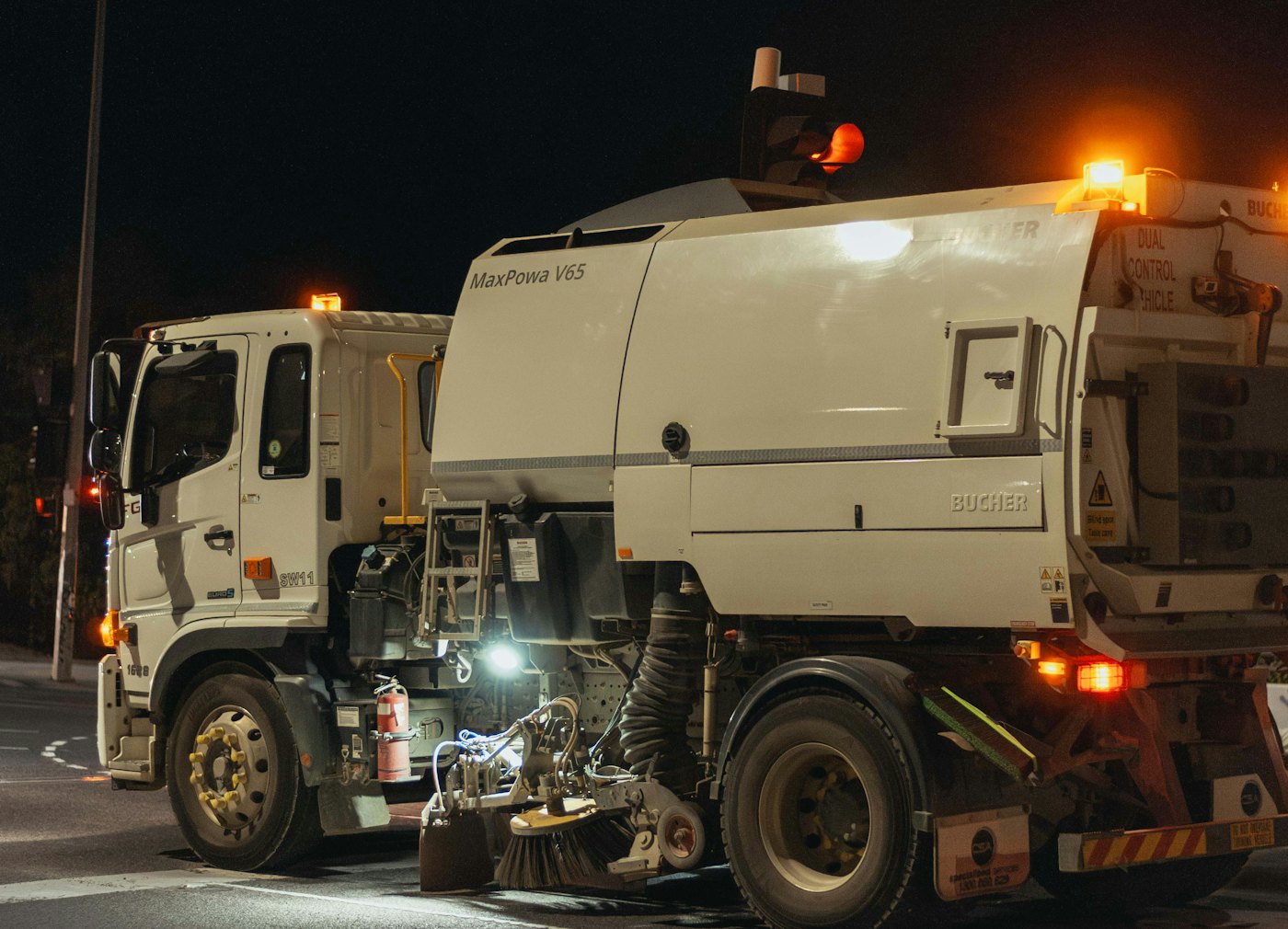 Parking lot sweeper truck working at night